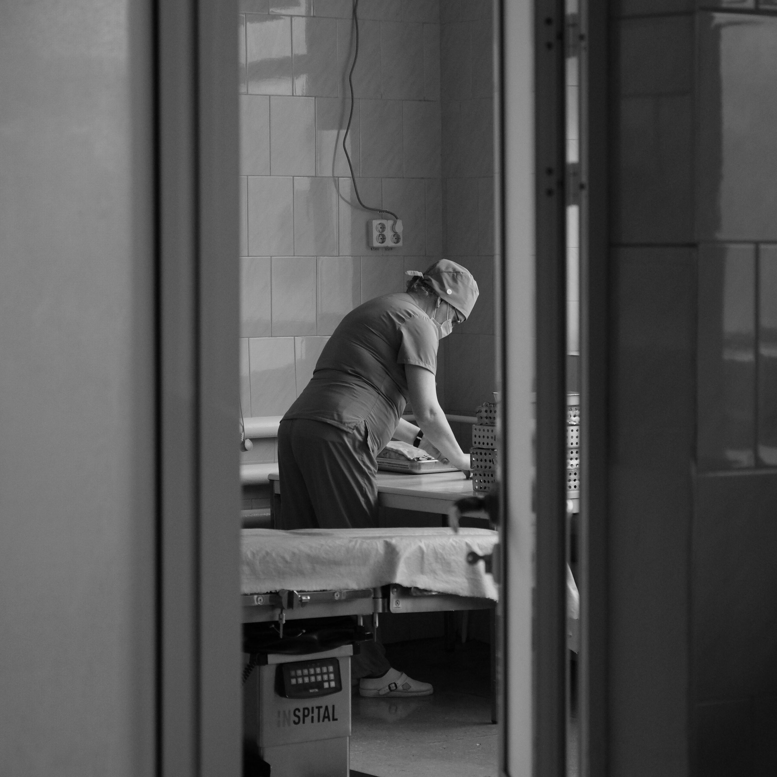 Black and white photo of healthcare worker preparing in a hospital operating room in Moldova Nouă, Romania.